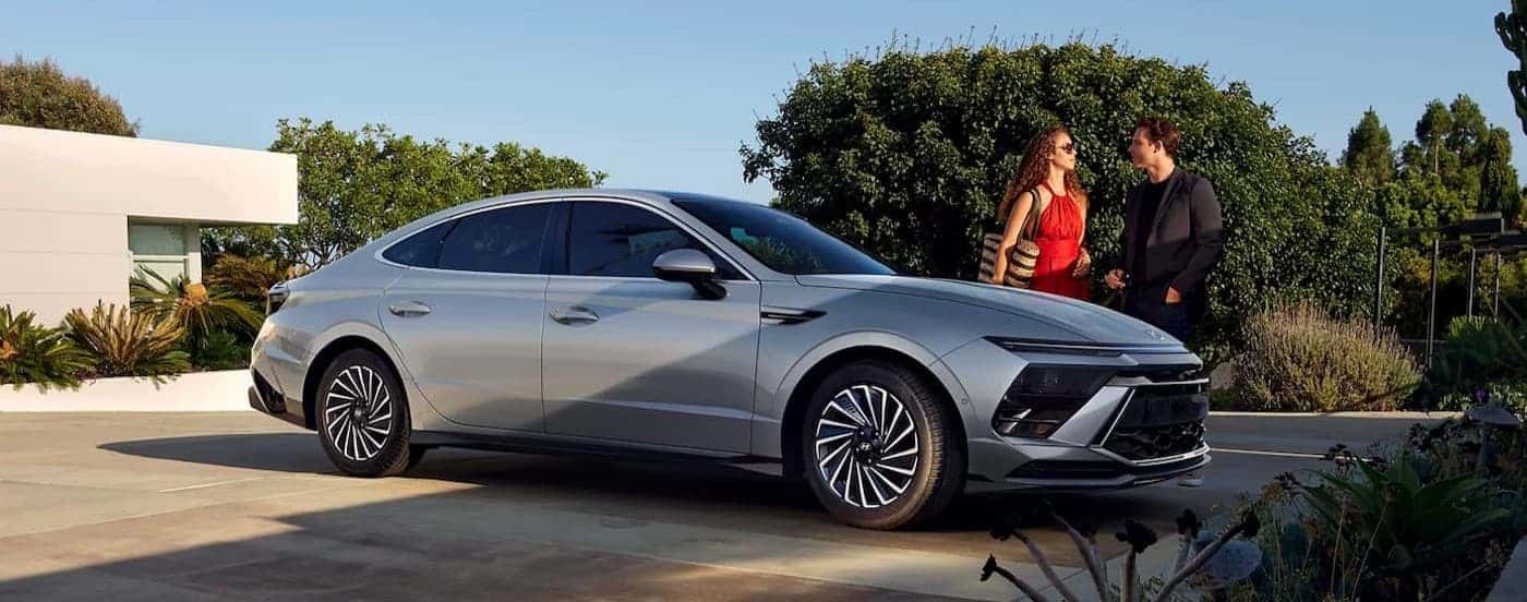 People standing near a silver 2027 Hyundai Sonata.