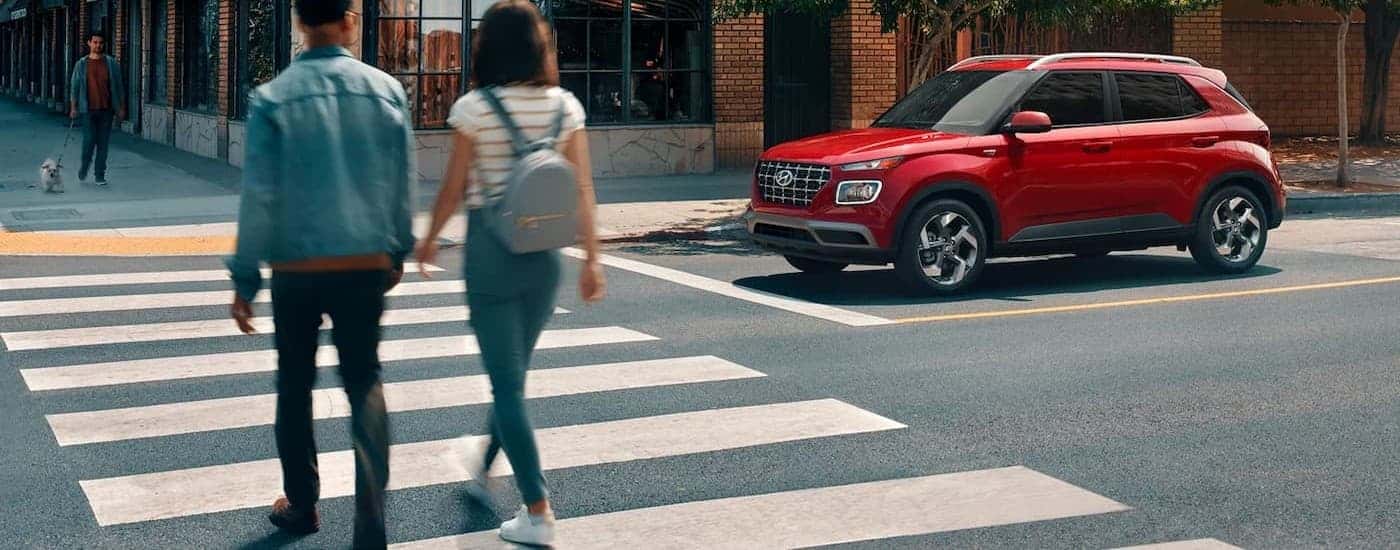 A red 2026 Hyundai Venue stopped near a crosswalk.