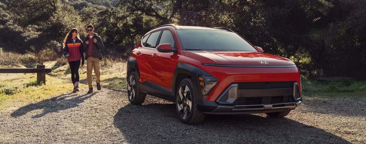 A red 2026 Hyundai Kona parked near people.