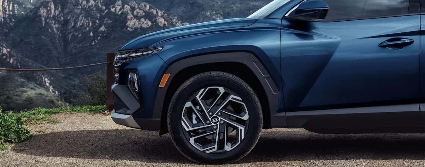 The frontend of a blue 2025 Hyundai Tucson.