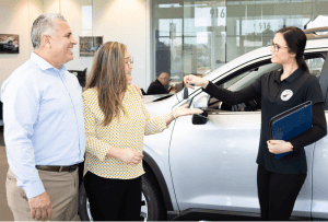 Couple receiving car keys from dealership employee