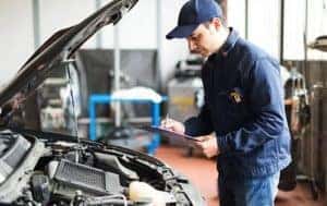 Mechanic checking engine of car
