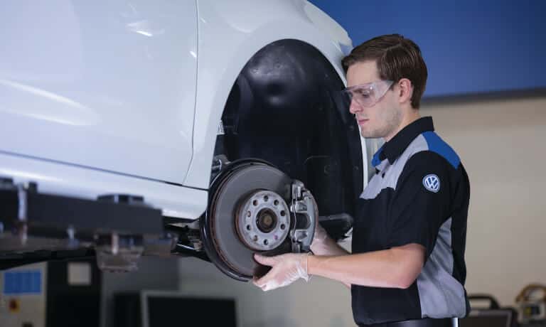 VW Service Tech Working On Brakes