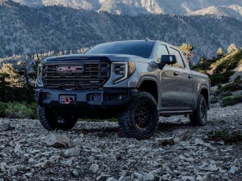 2024 GMC Sierra 1500 AT4 exterior view parked on rocks with mountains in the background