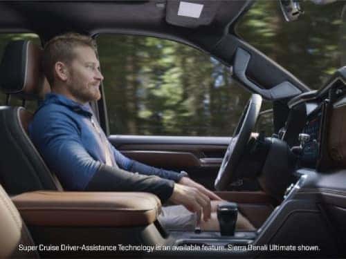 2024 GMC Sierra 1500 Denali side view of man in driver seat while truck is in super cruise mode