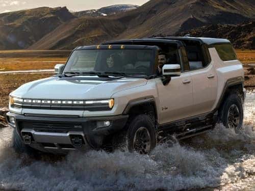 2025 GMC Hummer EV offroading through a small stream